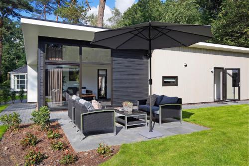 a patio with a table and an umbrella at Vakantiecentrum 't Schuttenbelt in Enter