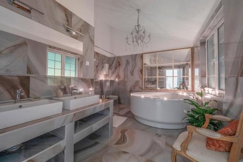 a large bathroom with two sinks and a tub at Marinero Apartments in Budva