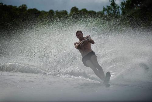 a man playing a musical instrument in the water at The Majlis Resort in Lamu