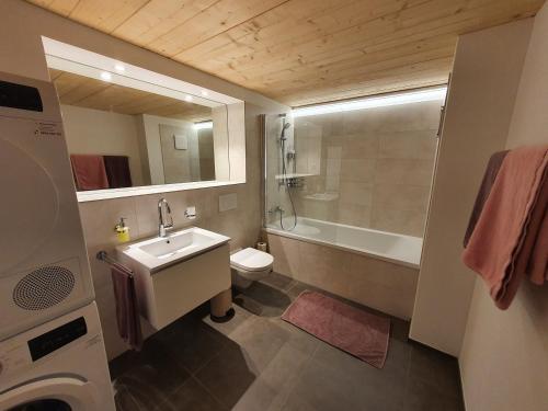 La salle de bains est pourvue d'un lavabo, de toilettes et d'une baignoire. dans l'établissement Wohnstation DIAMOND SUITE, à Subingen