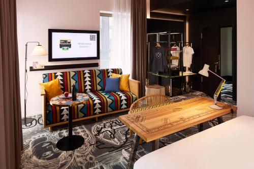 a living room with a couch and a table at Mama Shelter Luxembourg in Luxembourg