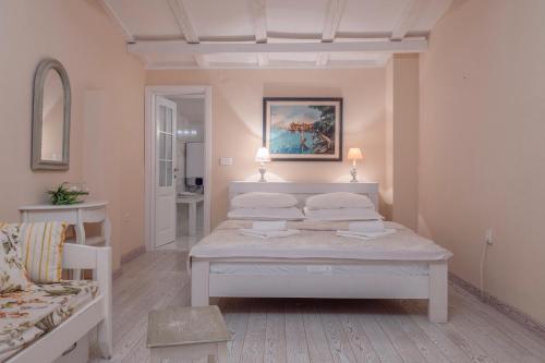 a bedroom with a white bed with two pillows at Marinero Apartments in Budva