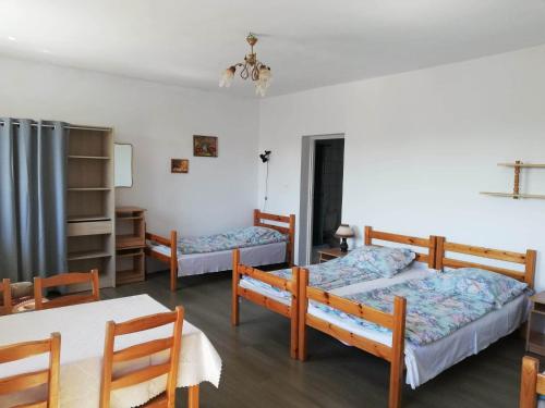 a bedroom with two beds and a table and chairs at Agrogospodarstwo HALINA ŁUC in Słajszewo
