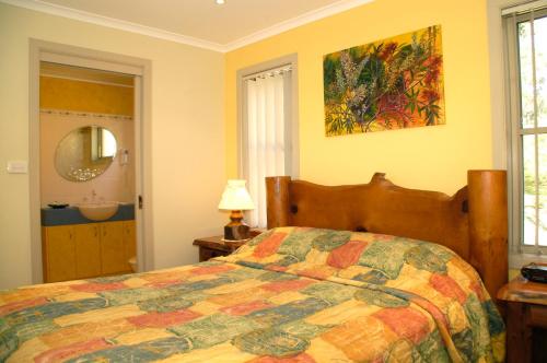 - une chambre avec un lit doté d'une couette colorée dans l'établissement Bewong River Retreat, à Bewong