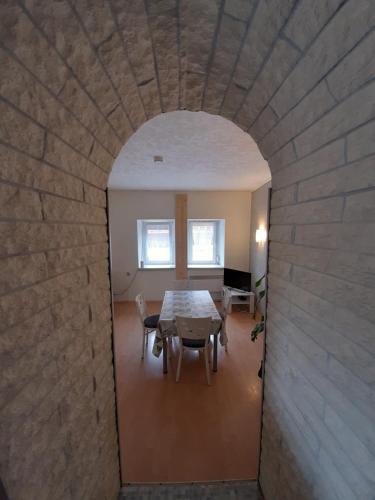 a dining room with a table and a brick wall at Townhouse for fitters / Haus für Monteure in Schraplau in Schraplau