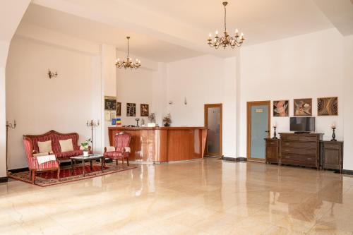 a large living room with a table and chairs at Hotel McPietroasa in Haleş