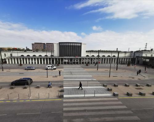 un gran edificio con gente caminando delante de él en La Consigne Caen Gare SNCF Centre, en Caen