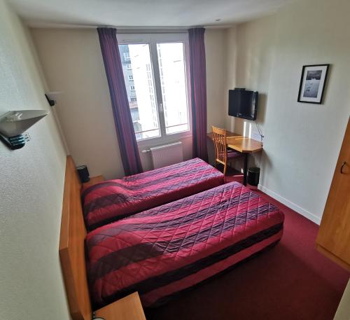 a hotel room with a bed and a window at La Consigne Caen Gare SNCF Centre in Caen