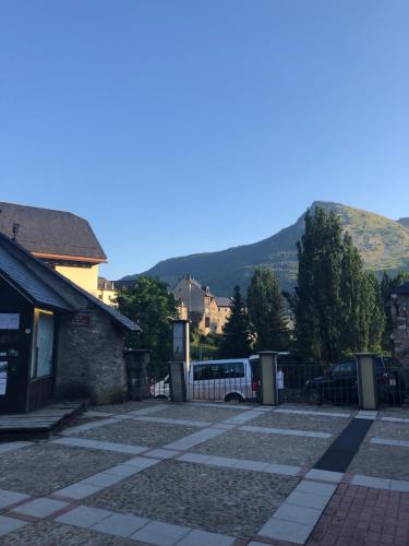 a bus parked in a parking lot with a mountain in the background at Apartamento céntrico, destino Sallent de Gallego in Sallent de Gállego