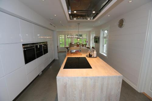 a large kitchen with a large wooden island in the middle at Alnes Gård in Alnes