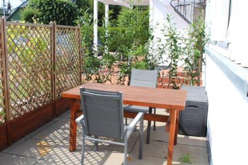 a wooden table and chairs on a patio at Haus Selma in Zingst