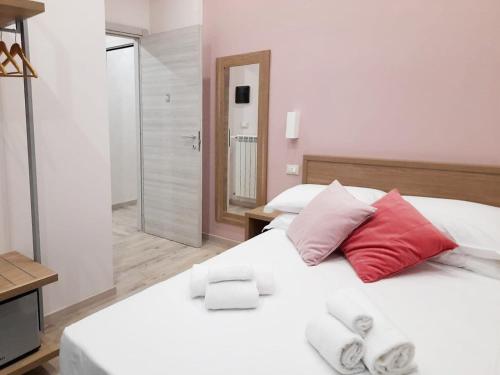a bedroom with a white bed with red and white pillows at A&B Affittacamere a Boccadasse in Genova