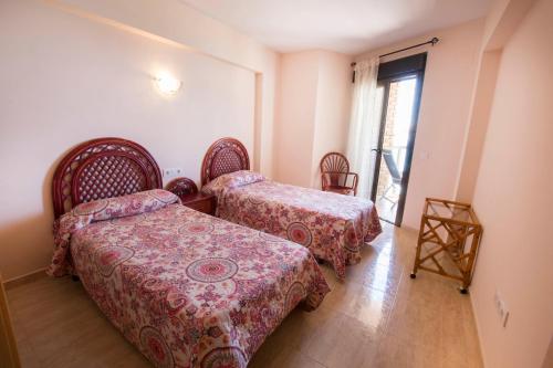 a room with two beds and a window at Edificio Calpemar in Calpe
