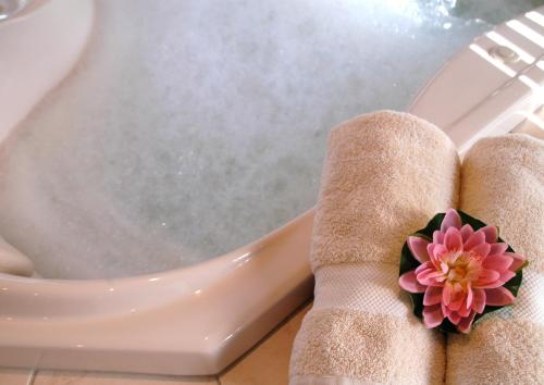 a person with their feet on a toilet with a flower on it at Bewong River Retreat in Bewong