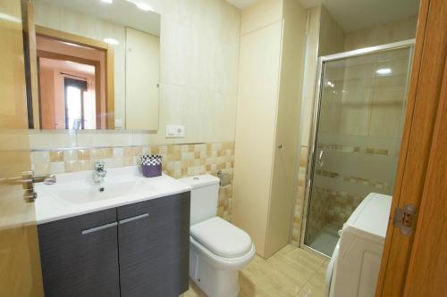 a bathroom with a toilet and a sink and a shower at Edificio Calpemar in Calpe
