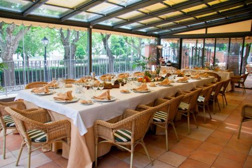 a long dining room with a long table and chairs at Hospedium Hotel Los Lanceros in San Lorenzo de El Escorial