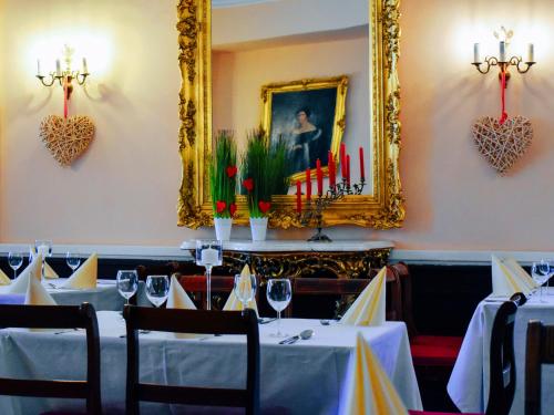 een eetkamer met tafels en een foto aan de muur bij Hotel Zamek Królewski w Rydzynie in Rydzyna