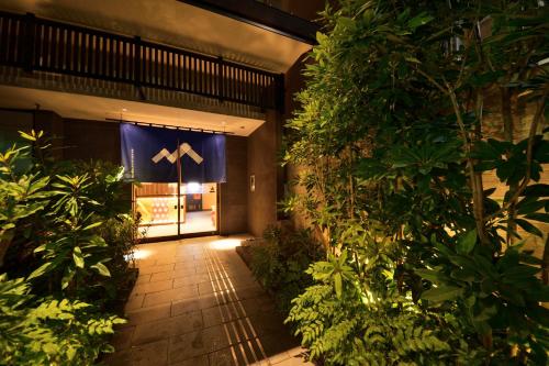 een toegang tot een gebouw met een bord erop bij Hotel MONDONCE Kyoto Gojo in Kyoto