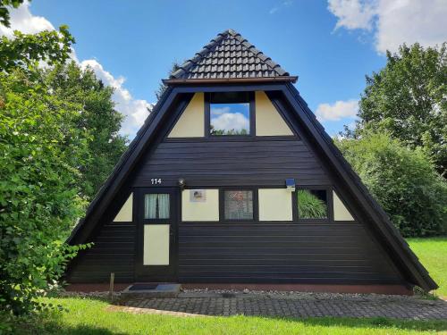 une maison noire et blanche avec un toit en gambrel dans l'établissement Ferienhaus Winnetou 114, à Waldbrunn