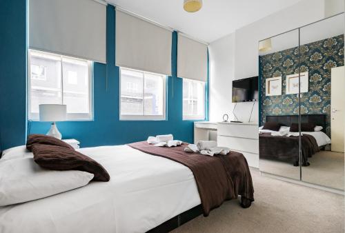 a bedroom with a large bed with blue walls at City Rooms in London