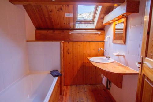 une salle de bain avec une baignoire et un lavabo et une baignoire dans l'établissement Chalet Le Mélézin hameau des Chazals Nevache Hautes Alpes, à Névache