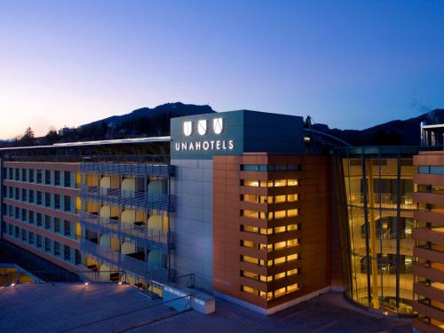 a building with a sign on top of it at UNAHOTELS Varese in Varese