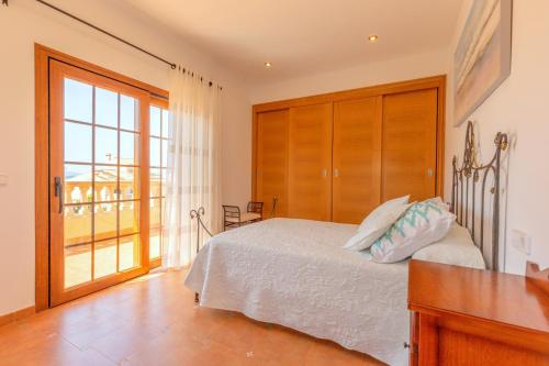 - une chambre avec un lit et une grande fenêtre dans l'établissement Marravilloso chalet Mes Blanc, à Son Serra de Marina