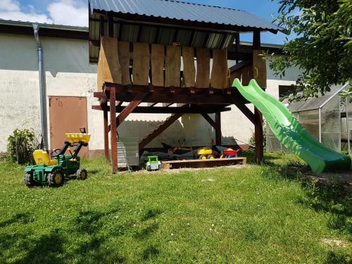 a playground with a slide and a green slide at Ferienwohnung/Monteurzimmer auf dem Bauernhof in Mörlenbach