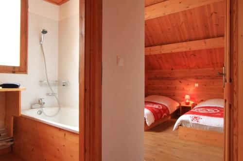 a bedroom with two beds and a bathtub in a room at Chalet L'Eitièro hameau des Chazals Nevache Hautes Alpes in Névache