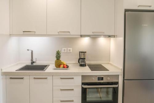 a kitchen with white cabinets and a counter top with a pineapple at Georgia Villas in Skiathos