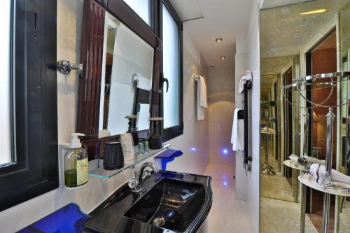 bagno con lavandino nero e specchio di Hotel Le Meurice a Nizza