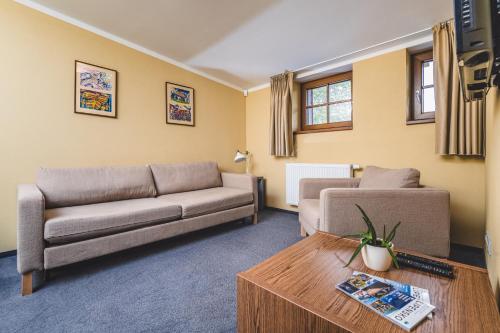 a living room with a couch and a table at Hotel Resort Relax in Dolní Vltavice