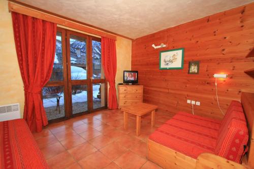 sala de estar con sofá y ventana en Le Barlèt23 pers Hameau des Chazals Nevache Hautes Alpes, en Névache