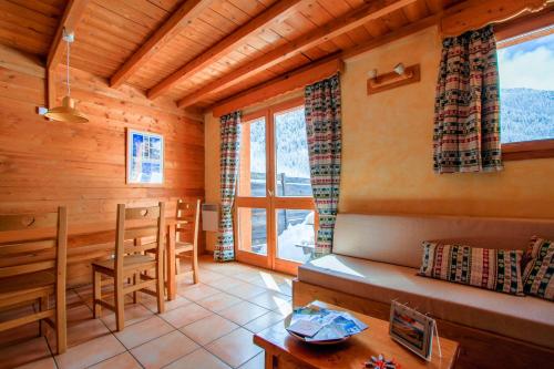 a living room with a table and a dining room at Le Gouroùn Hameau des Chazals Nevache Hautes Alpes in Névache