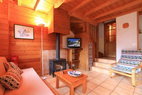 a living room with a fireplace in a log cabin at Le Gouroùn Hameau des Chazals Nevache Hautes Alpes in Névache
