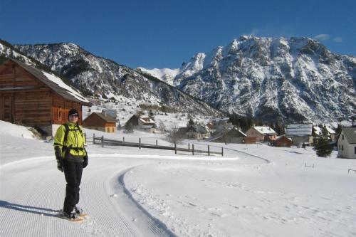 a person standing in the snow in front of a mountain at Le Barlèt23 pers Hameau des Chazals Nevache Hautes Alpes in Névache