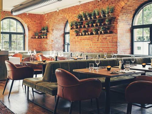 a restaurant with tables and chairs and a brick wall at Gastwerk Hotel Hamburg in Hamburg