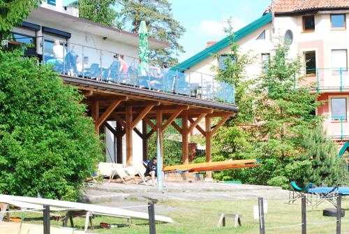 a building with a deck with people sitting on it at Krokodyl Sport&Spa in Mielno