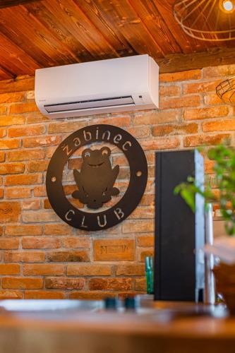 a sign for a restaurant on a brick wall at Žabinec - penzion, vinotéka in Kurdějov