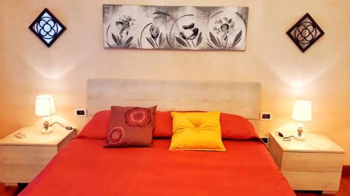 a bedroom with a large red bed with two lamps at Casa Vacanza La Isla Bonita in Isola delle Femmine