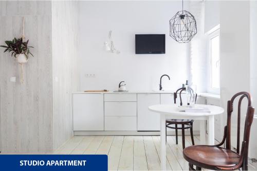 a kitchen with a table and chairs and a sink at Apartamenty Zacisze in Łódź