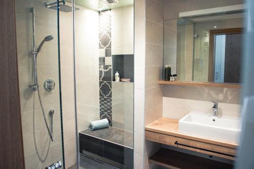 uma casa de banho com um chuveiro e um lavatório. em 423 - Penthouse apartment centrum Mayrhofen near ski area em Mayrhofen