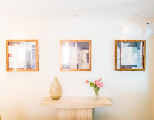 a table with a vase and three mirrors on a wall at Cedar House Boutique B&B in Burton