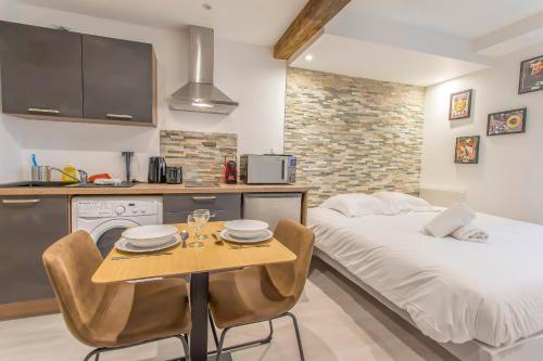 une chambre avec un lit et une table avec des chaises dans l'établissement R’Studio 18 Hyper Centre, à Grenoble