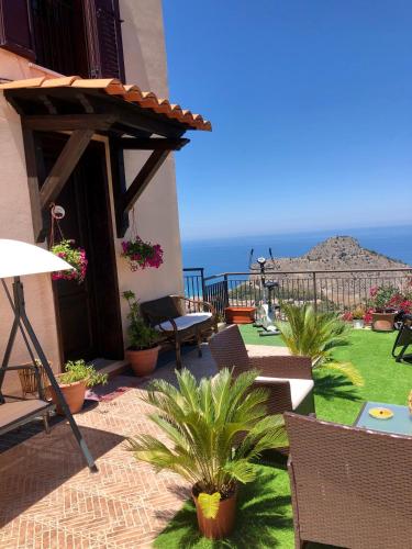 a patio with chairs and a view of the ocean at B&B Roomantic & Piscina Idromassaggio in Cefalù