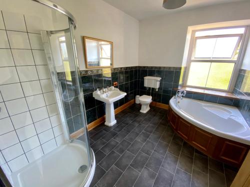 a bathroom with a tub and a toilet and a sink at Flatts farm, Yorkshire dales home in Skipton