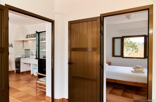 a bedroom with a door leading to a bed at Can Nigg in Playa Migjorn