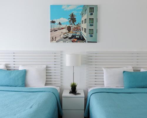 two beds in a bedroom with blue and white at Snooze in Fort Lauderdale