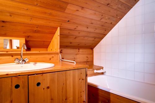 une salle de bain avec un lavabo et une baignoire dans l'établissement Le Pignotto Hameau des Chazals Nevache Hautes Alpes, à Névache