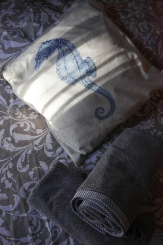 a bag with a seahorse on it sitting on a bed at A Casa di Claudia in Loreto